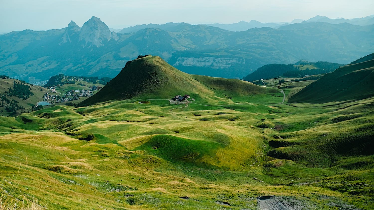 A green hill with a cone-like shape without the top, visible from the stoos ridge trail