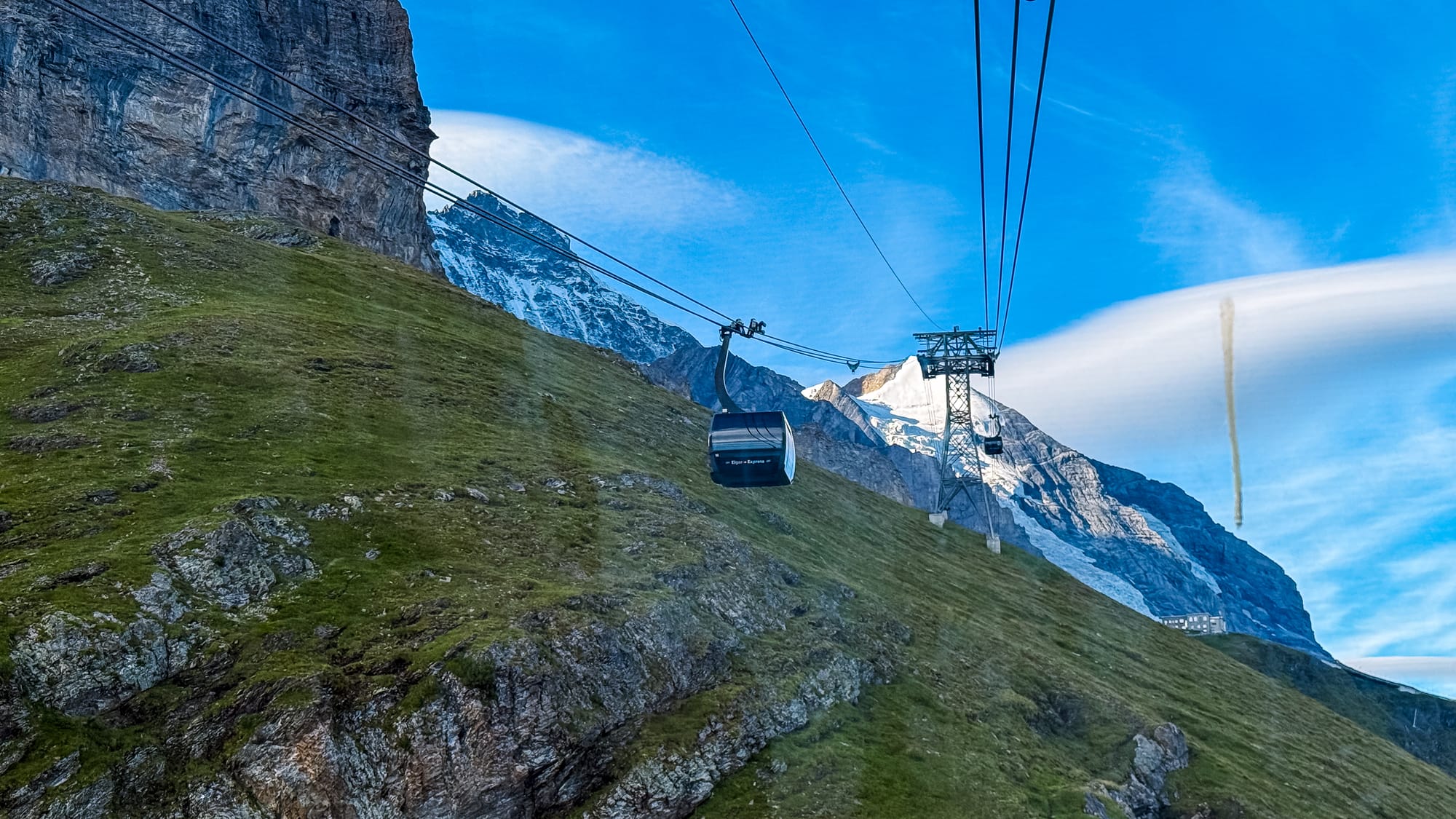 Eiger Express cabin climbing the cable over a grassy mountainside