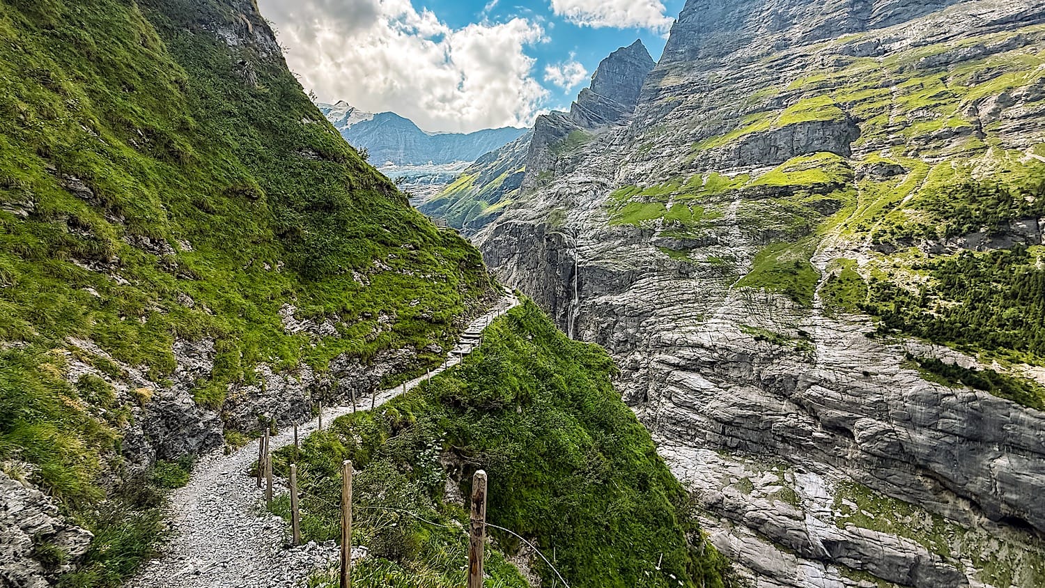 Narrow trail climbing across rock slabs toward the Bäregg Hut
