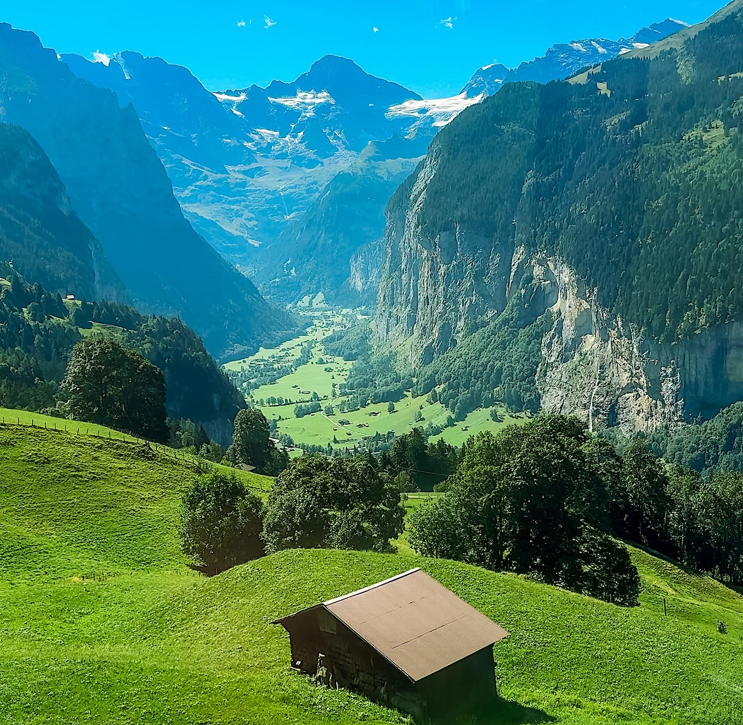 View of the Lauterbrunnen Valley and a wooden barn from the train